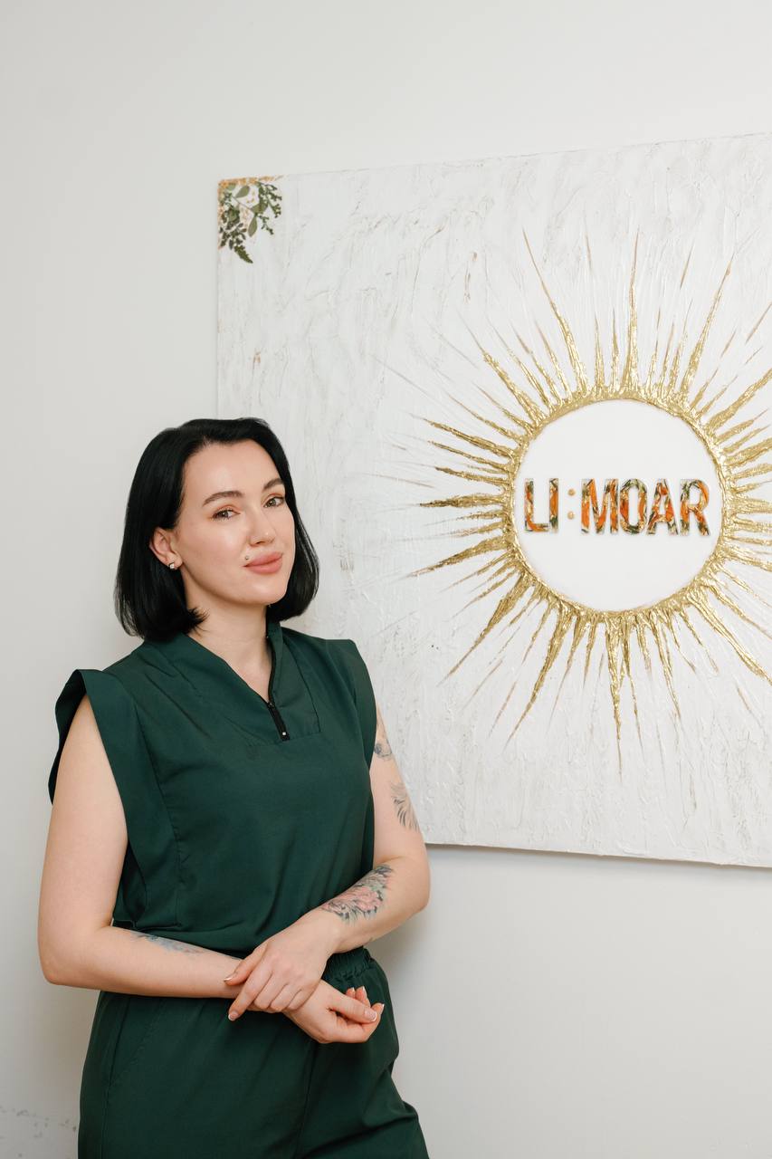 Лиза Жигула на фоне картины с логотипом бренда LI:MOAR